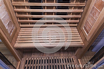 Infrared sauna interior close up view. Wooden walls and bench, ceramic heaters. Healthy lifestyle concept Stock Photo