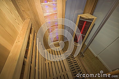 Infrared sauna interior close up view. Wooden walls and bench, ceramic heaters. Healthy lifestyle concept Stock Photo
