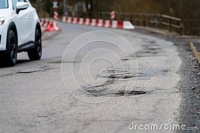 Pothole - Infrastructure degradation. Poor condition of the road surface. Winter season. Hole in the asphalt, dangerous road Stock Photo