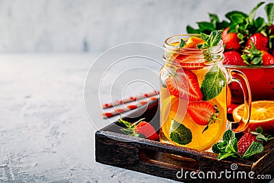 Infused detox water with orange, strawberry and mint. Ice cold summer cocktail or lemonade. Stock Photo