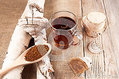 Infusion of chaga mushrooms in a glass cup on a wooden background with burlap in a rustic style. Healthy beverage. View from above Stock Photo