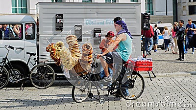 Man on Bike Selling Pretzels at Brandenburg Gate, Berlin Editorial Stock Photo