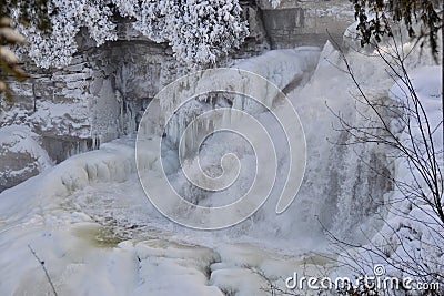 Inglis Falls flowing during Winter surrounded by huge icicles Stock Photo