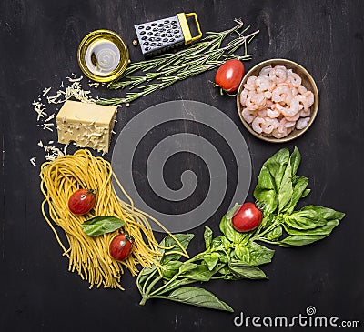 Ingredients for cooking pasta with shrimp, herbs, tomatoes, cheese lined frame place for text wooden rustic background top view Stock Photo