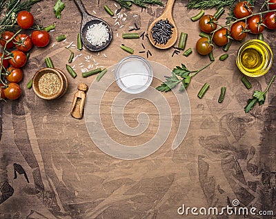 Ingredients for cooking vegetarian food cherry tomatoes, spices, herbs, oil, colorful rice in wooden spoons border ,place for tex Stock Photo