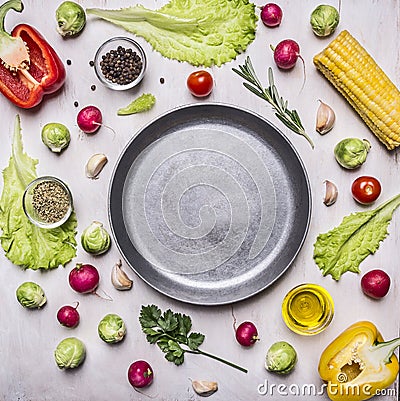 Ingredients for cooking vegetarian food, corn, radishes, rosemary, pepper, oil, seasonings, lined around pan place for text,fr Stock Photo