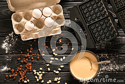 Ingredients and device for cooking Belgian waffles on dark wooden table Stock Photo