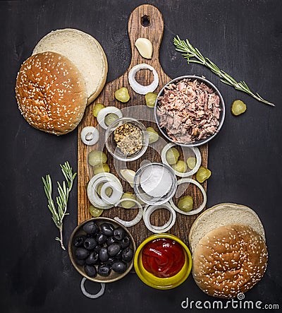 Ingredients for home kuking burger with tuna, pickled cucumbers, onions, olives sauce cutting board wooden rustic back Stock Photo