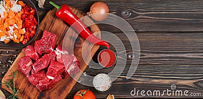 Ingredients for making goulash or stew, stew or gyuvech: top view of raw beef meat, herbs, spices, paprika, vegetables on a dark Stock Photo