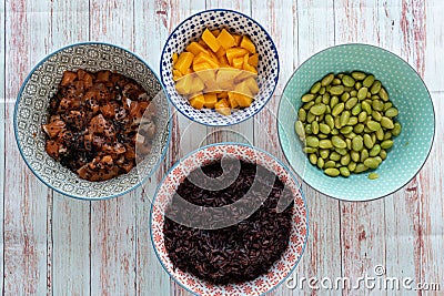 Ingredients for a poke in a bowl. Tomatoes, black rice, tuna or salmon, mango and soybeans Stock Photo