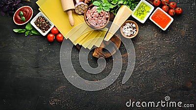 Ingredients for the preparation of Lasagna. Tomatoes, sauce, pasta. On a black background. Top view. Stock Photo