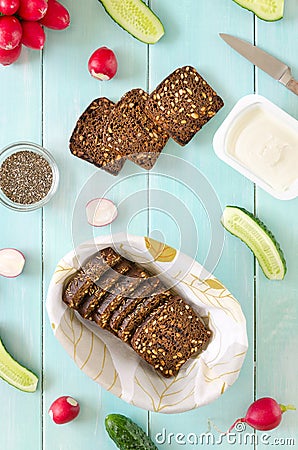 Ingredients for vegan sandwich with cream cheese, fresh cucumber, radish and chia seeds on mint wooden background. Stock Photo