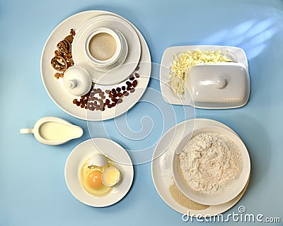 Ingredients for yeast fermented dough. In white porcelain utensils the layout on a blue background Stock Photo