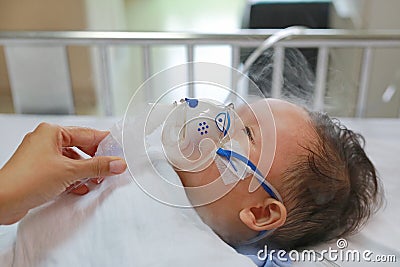 Inhalation baby boy age about 1 years old on patient bed. Respiratory Syncytial Virus RSV. Intensive care on bed at hospital Stock Photo