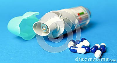 inhaler and pills against asthma on blue background. COPD Stock Photo