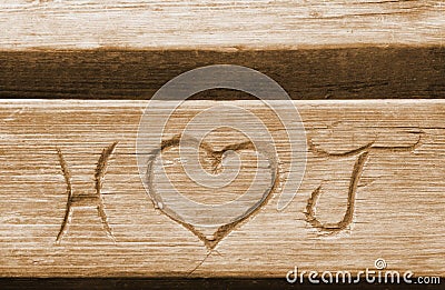 Initials of a love couple, carved in a bench plank Stock Photo