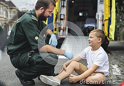 Injured boy getting help from paramedics Stock Photo