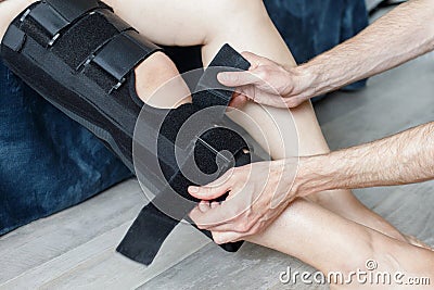 Injured knee in orthopedic bandage. Female in knee brace closeup Stock Photo