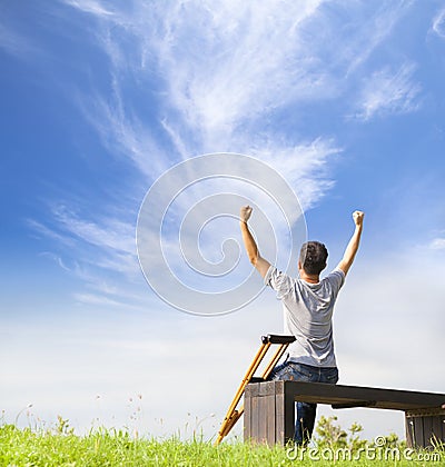 Injured Man raise hands and sitting on a bench with Crutches Stock Photo