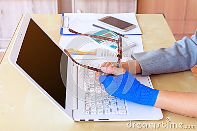 injured woman with blue elastic bandage on hand and holding eyeg Stock Photo