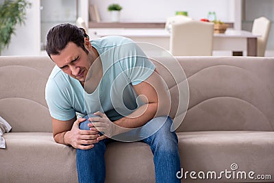 Injured young man suffering at home Stock Photo