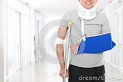 Injured young man use crutch and arm sling Stock Photo