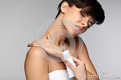 Injury Treatment. Beautiful Woman With Neck Pain Applies Cream Stock Photo