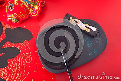 Inkstone and writing brush on red background Stock Photo