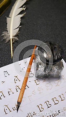 Inkwell with quill, quill, nib and sheet with gothic letters Stock Photo