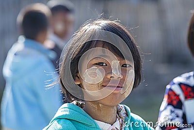 A young girl from Myanmar with Tanaka on her face in yard near local school, Burma Editorial Stock Photo