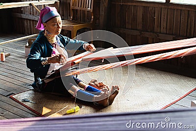 Inle, Myanmar - March 2019: Kayan Lahwi tribe long neck woman sits behind the loom Editorial Stock Photo