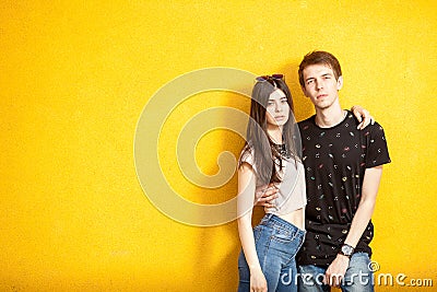 Inlove couple posing in fashion style on yellow wall Stock Photo