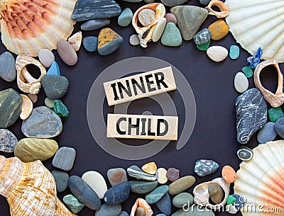 Inner child symbol. Concept words Inner child on beautiful wooden block. Beautiful black table black background. Sea stone sea Stock Photo