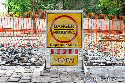 Inner city road with old pavement, closed by stone roadblocks during reconstruction. Yellow roadsign with the words in Ukrainian Stock Photo