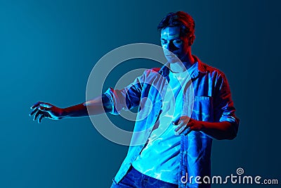 Inner sense, intuition. Young man in casual clothes with closed eyes standing with digital neon filter light reflection Stock Photo