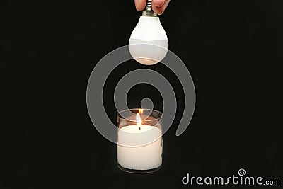 The innovation is a candle and new economical light bulbs on a black background Stock Photo