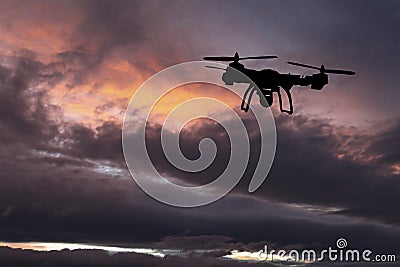 Innovation concept. Silhouette of drone flying on sunset. Heavy lift drone photographing Stock Photo