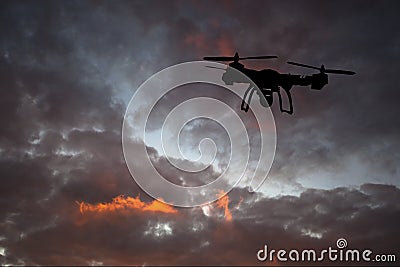 Innovation concept. Silhouette of drone flying on sunset. Heavy lift drone photographing Stock Photo