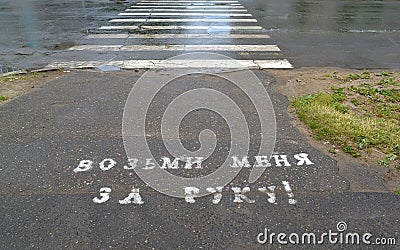 Inscription on asphalt in Russian Take me by hand!`. Crosswalk Stock Photo