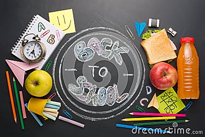 The inscription back to school, on a school board with handles, chalk, an alarm clock, and school breakfast Stock Photo