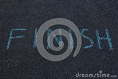 Inscription on black asphalt - FINISH. Word written with chalk on pavement Stock Photo