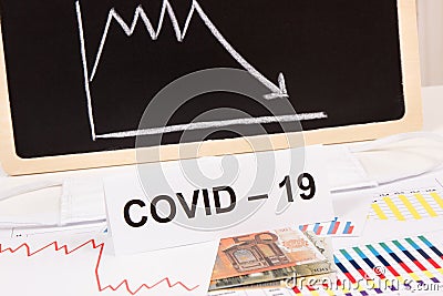 Inscription Covid-19, euro and downward graphs representing financial crisis caused by coronavirus. Risk of recession around world Stock Photo