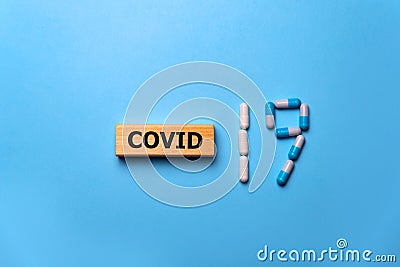 Inscription COVID-19 with pills on blue background. World Health Organization WHO introduced new official name for Coronavirus Stock Photo