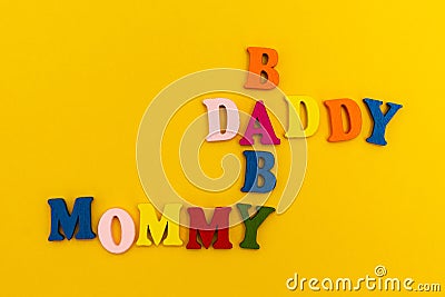 The inscription `Daddy, Mommy, Baby` in colorful letters on a yellow background Stock Photo