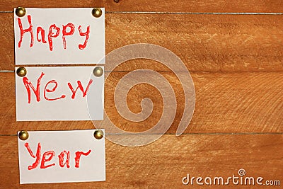 Inscription happy new year on white sheets of paper. background wood natural. Stock Photo