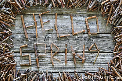 The inscription Hello spring with wooden sticks on wooden background. Stock Photo