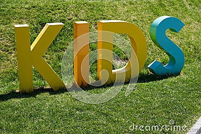 Inscription KIDS made in 3D form standing on green grass Stock Photo