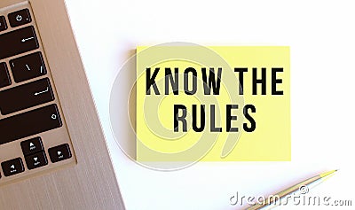 The inscription KNOW THE RULES on the yellow sticky notes on the white office desk. Stock Photo