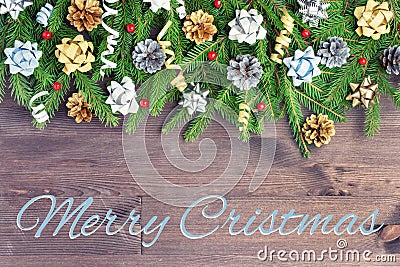 The inscription Merry Christmas on a dark wooden background. Christmas composition of fir branches decorated with silver Stock Photo