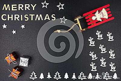 The Inscription Merry Christmas made of wooden letters, lying flat from above, isolated on a black background. Visible wooden Chri Stock Photo